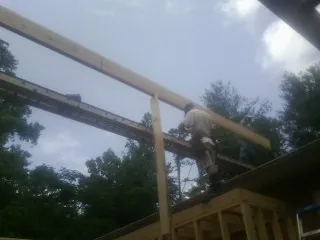 Carpenter setting a ridge beam over a new addition frame — Ice Dam Removal by Roofing Brothers in Kansasville