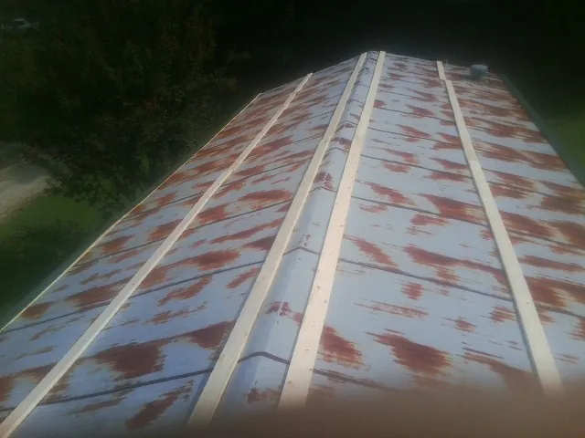 Rusted metal roof panels with new wood purlins before replacement — Storm Damage Roof Repair in Kansasville by Roofing Brothers