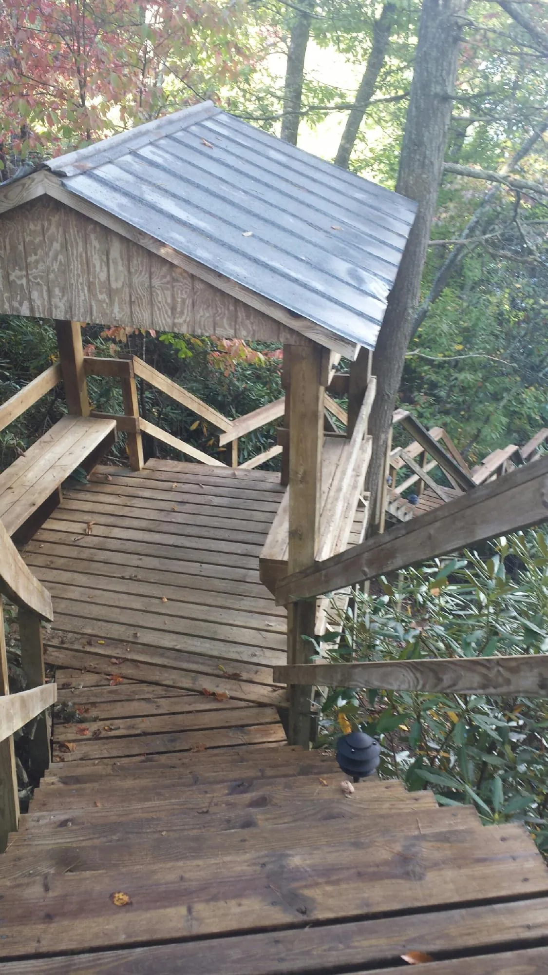 Metal roofed shelter over wooden steps on a wooded walkway — Skylight Repair & Installation work by our crew in Kansasville
