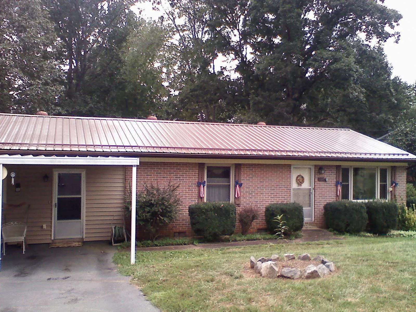 Bronze metal roof and carport on a brick ranch home — Roof Repair work by our crew in Kansasville
